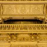 ...si apre un balconcino �sorretto� da sei angeli tra riproduzioni di strumenti musicali. Il ballatoio � sovrastato da una scena classicheggiante di putti intenti a suonare la tromba, grifoni accovacciati e anfore attorniate da fronde arboree